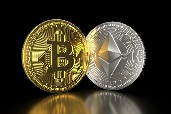 Picture of two crypto coins, a gold bitcoin and a silver ethereum, standing side by side